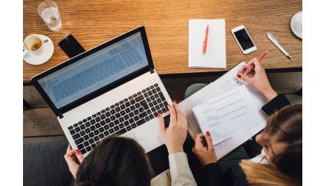2 people watching laptop info